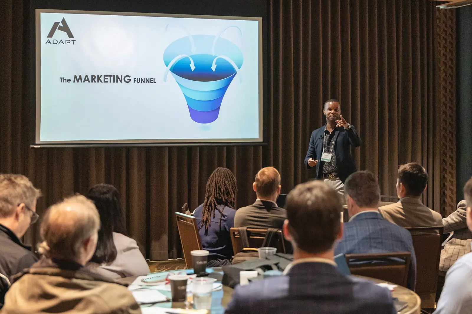 Merrick Lee Jr. presenting a marketing funnel slide, the framework behind his marketing audit