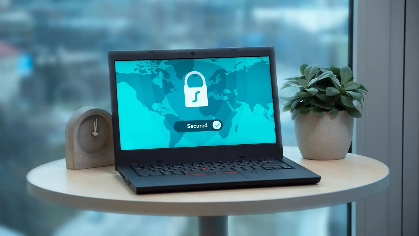 Laptop showing a security lock screen on a small table