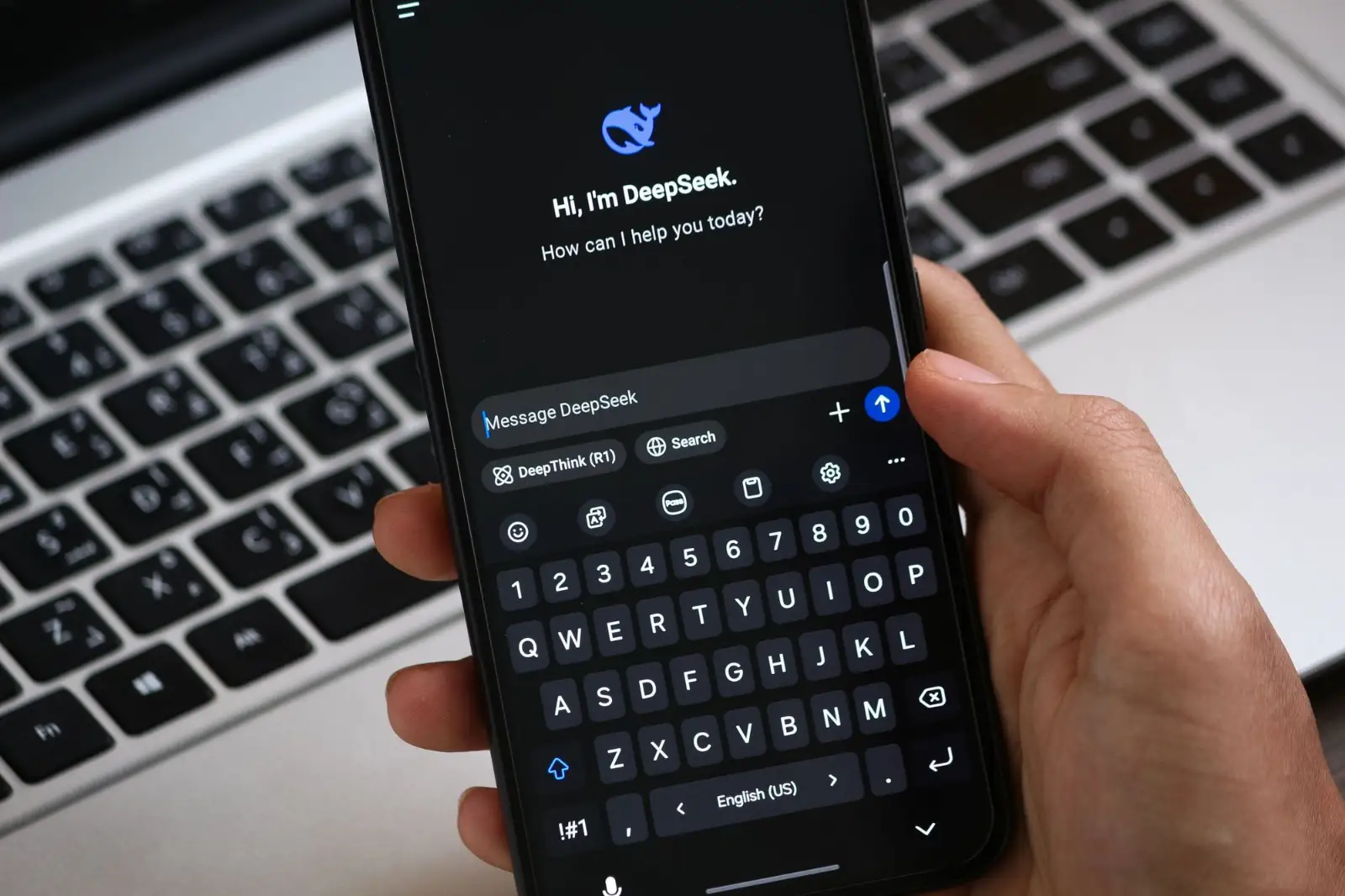 Hand holding a smartphone with an AI chat assistant open