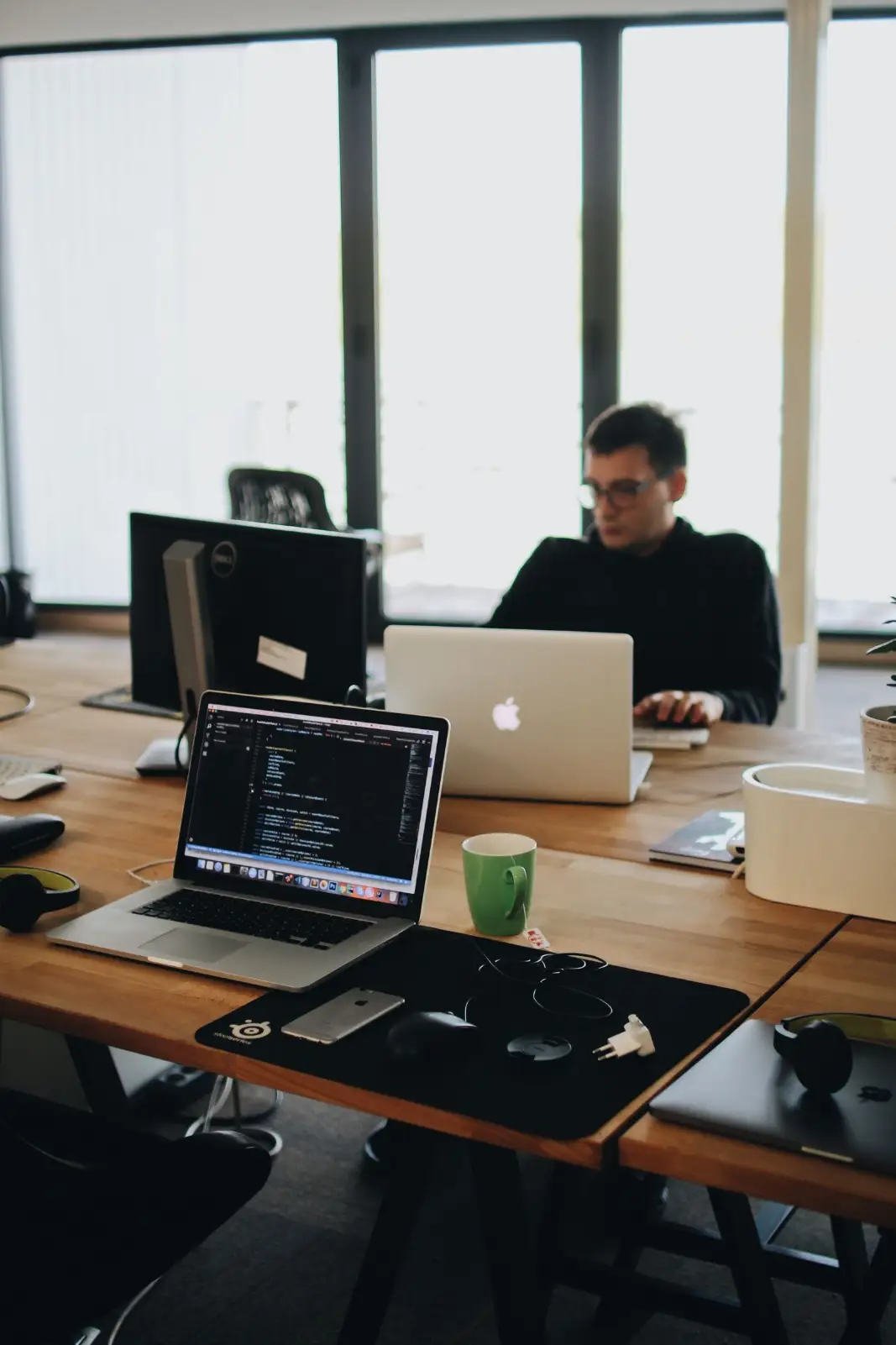 Analyst working at a desk with several screens reviewing website data