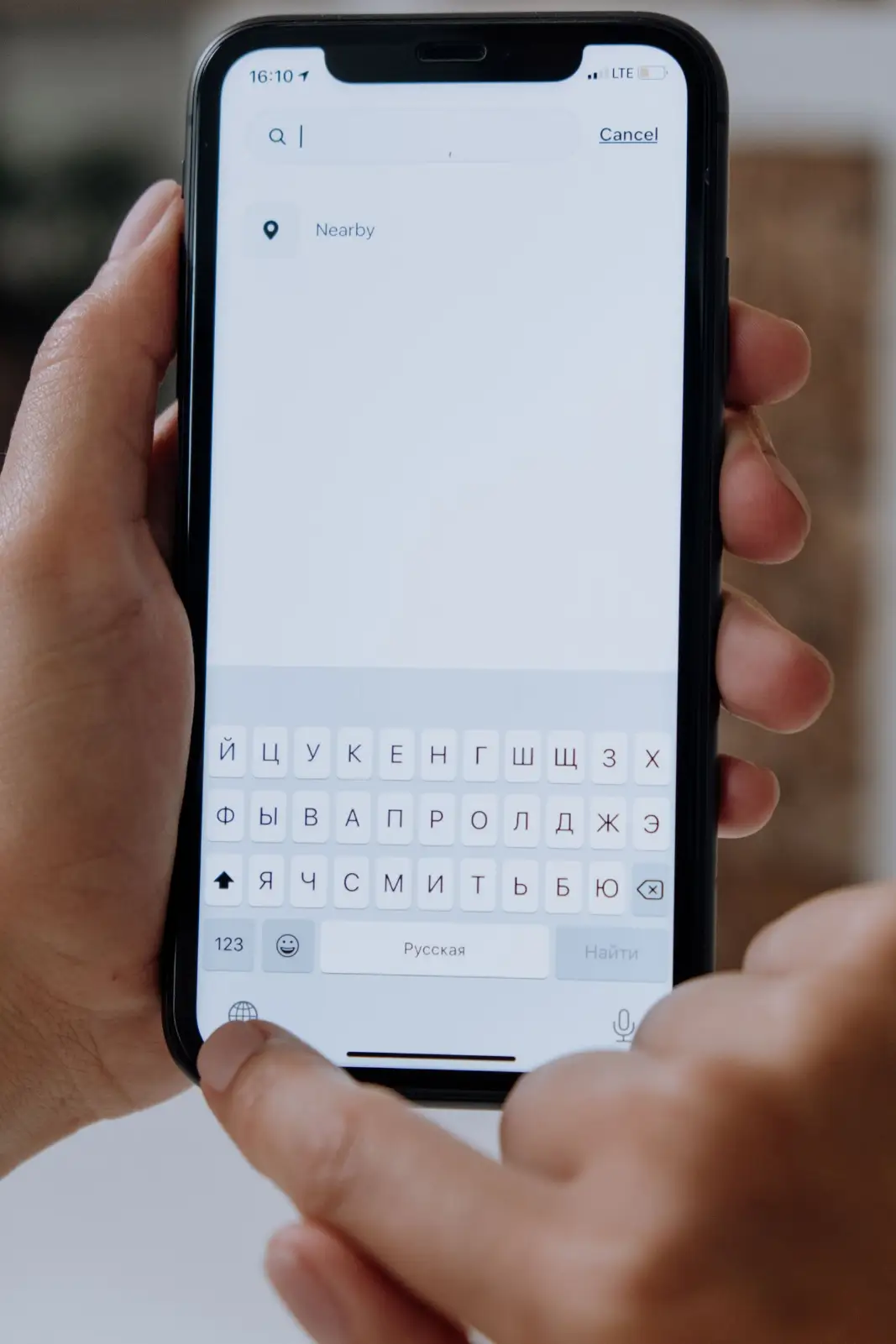 Hands typing a question into a search app on a smartphone