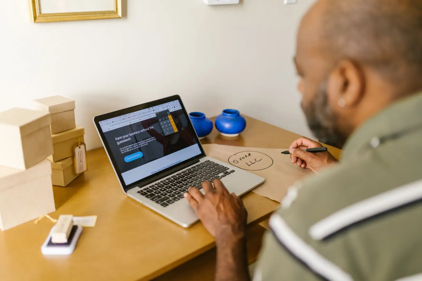 Business owner reviewing a website page on a laptop and taking notes