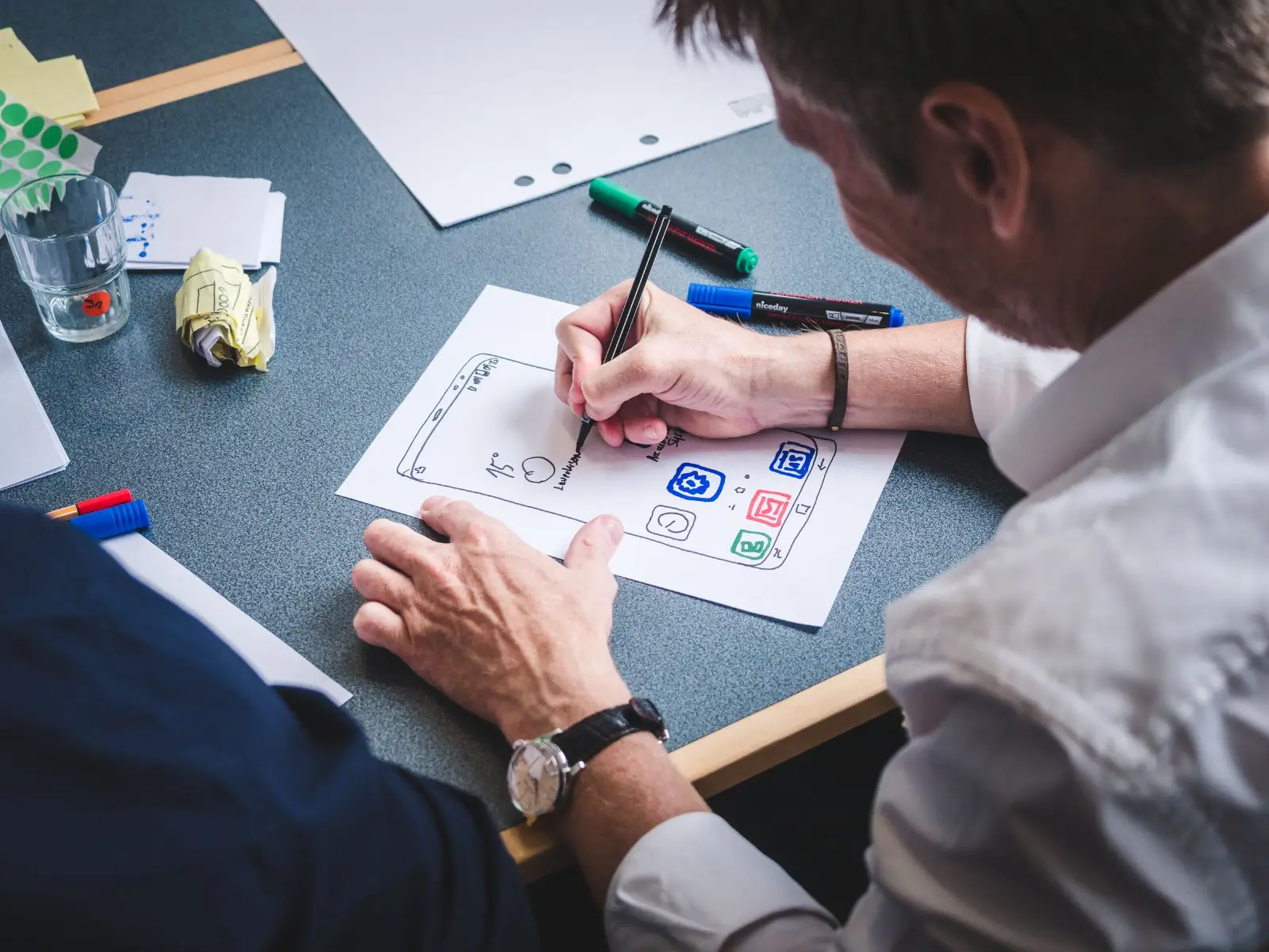 Designer sketching page wireframes on paper before building a website
