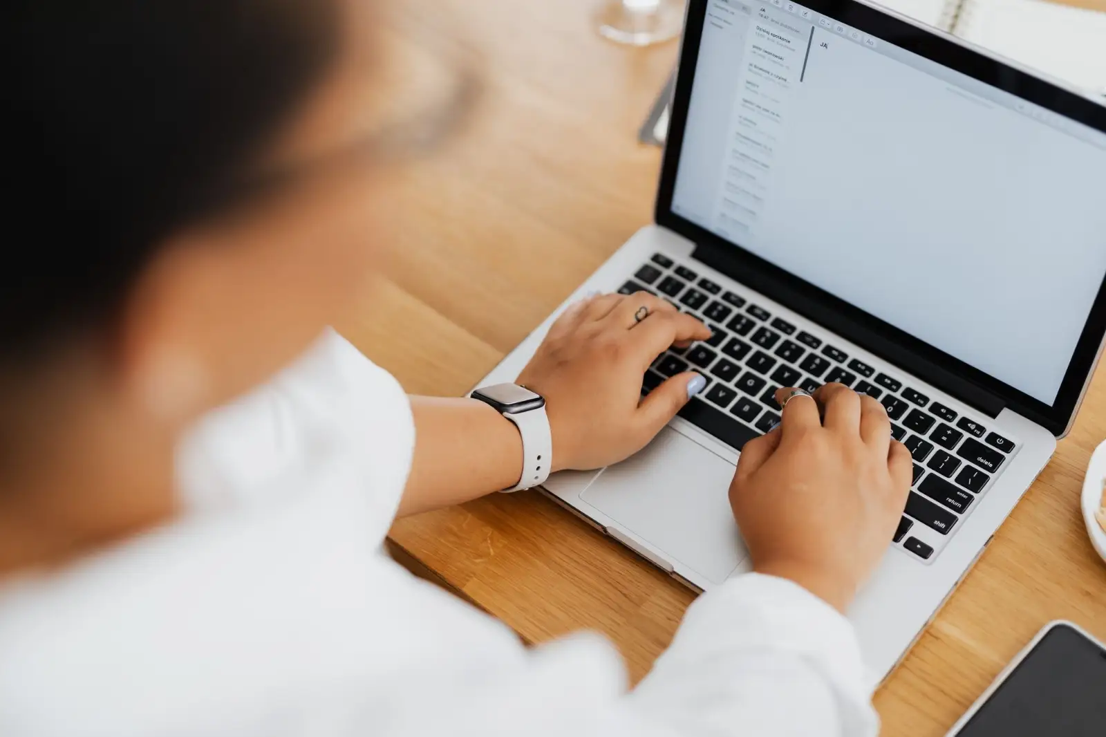 Hands typing a question into a business app on a laptop