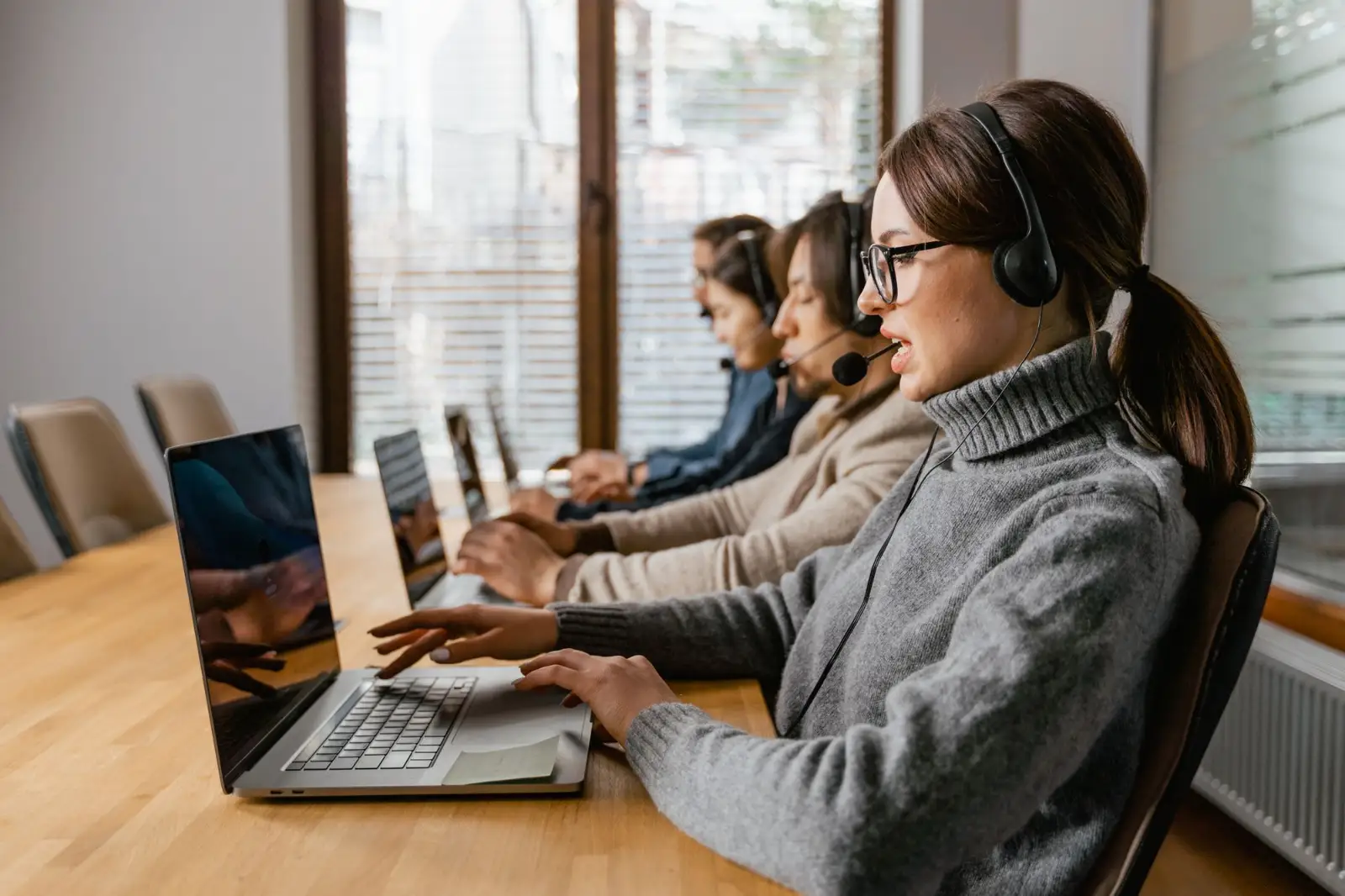 Customer service team with headsets answering incoming calls